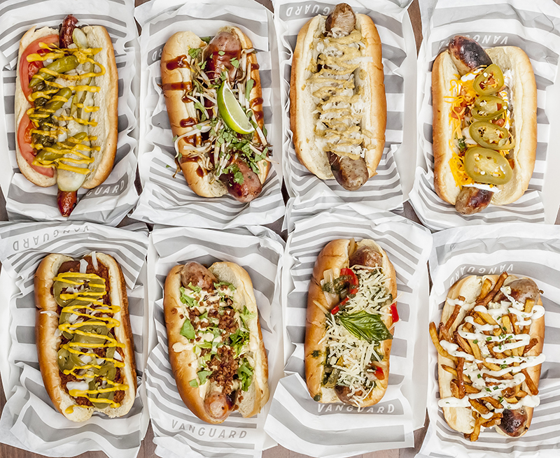 Eight varieties of house-made sausages and loaded dogs lined up in Vanguard wrappers