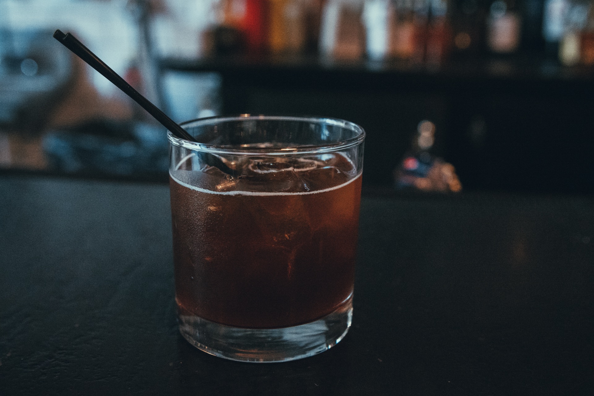Amber bourbon cocktail in a rocks glass with a large ice cube
